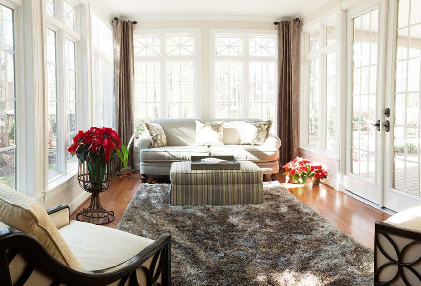 Bright sunroom with large windows, a plush sofa and a shaggy rug